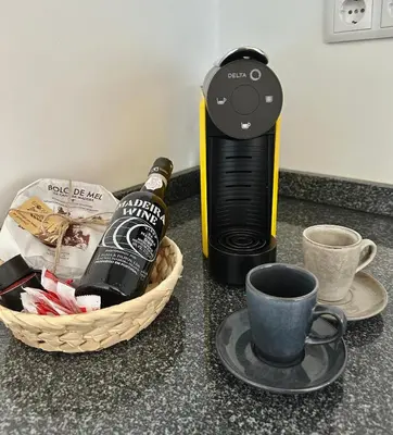 a bottle of wine and a cup of coffee on a counter at Oásis Suites - Funchal in Funchal