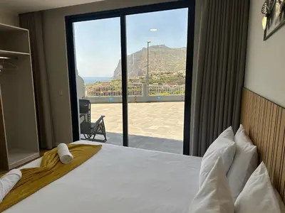 a bedroom with a bed with a view of a mountain at Oásis Suites - Funchal in Funchal