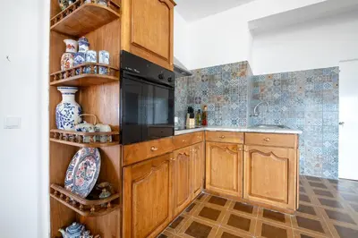 a kitchen with wooden cabinets and a black appliance at Casa da Silva home in Funchal in Funchal