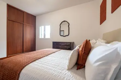 a bedroom with a large bed with a wooden cabinet at Casa da Silva home in Funchal in Funchal