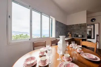 a dining room with a table with plates and glasses at Casa da Silva home in Funchal in Funchal