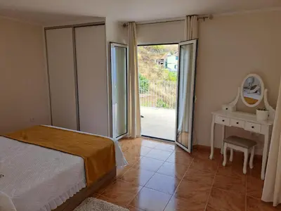 a bedroom with a bed and a sliding glass door at Success House in Calheta