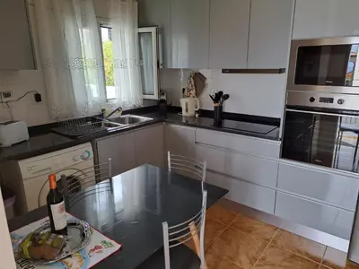 a kitchen with a table with a bottle of wine at Success House in Calheta