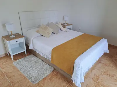 a bedroom with a large white bed with a night stand at Success House in Calheta