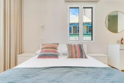 a bedroom with a bed with two pillows and a mirror at Q Studios by Atlantic Holiday in Funchal
