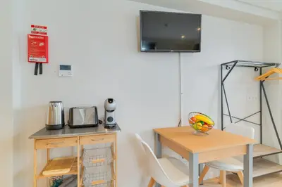 a dining room with a table and a tv on the wall at Q Studios by Atlantic Holiday in Funchal