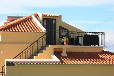 a house with a balcony with a plant on it at Casinha Gomes in Calheta