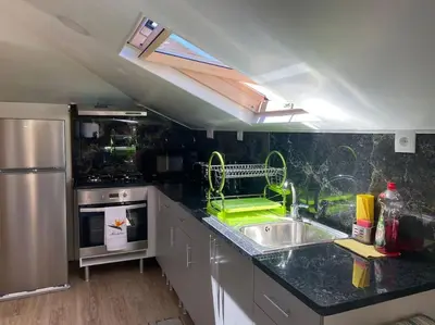 a kitchen with a sink and a stove and a window at Casinha Gomes in Calheta