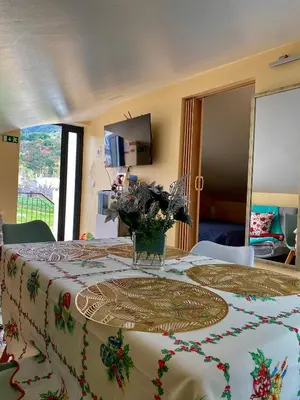a room with a table with a vase of flowers on it at Casinha Gomes in Calheta