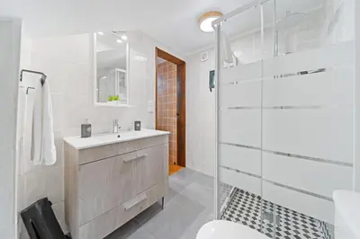 a bathroom with a sink and a glass shower at Mountain View Cottage in Seixal