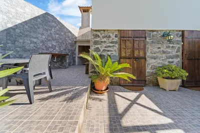 a patio with a table and a chair and a plant at Mountain View Cottage in Seixal