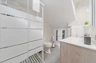 a white bathroom with a toilet and a sink at Mountain View Cottage in Seixal