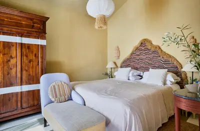a bedroom with a large bed and a chair at Pirate House Sea front Private Pool Garden Funchal in Funchal