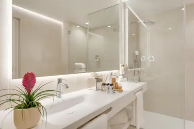 a bathroom with a sink and a large mirror at The Editory Ocean Way Funchal in Funchal