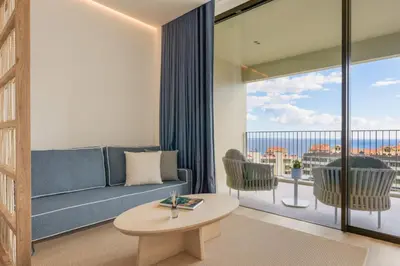 a living room with a couch and a large window at The Editory Ocean Way Funchal in Funchal