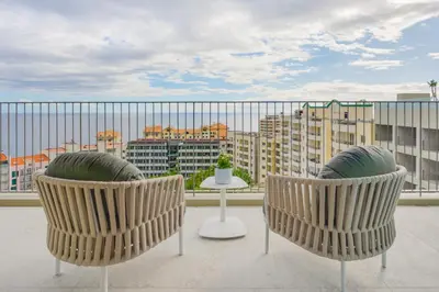 two chairs and a table on a balcony with a view at The Editory Ocean Way Funchal in Funchal