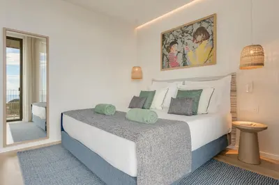 a bedroom with a large white bed and a window at The Editory Ocean Way Funchal in Funchal