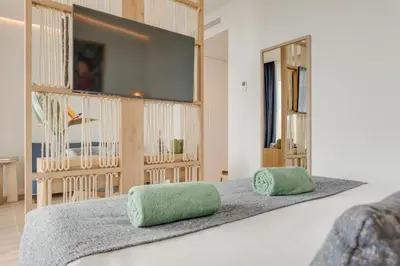 a bedroom with a bed with two green pillows at The Editory Ocean Way Funchal in Funchal