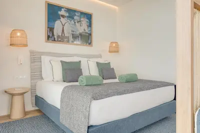 a bedroom with a large white bed with green pillows at The Editory Ocean Way Funchal in Funchal