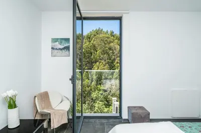 a bedroom with a bed and a chair and a window at SUPER Camacha - Casa da Eira in Camacha