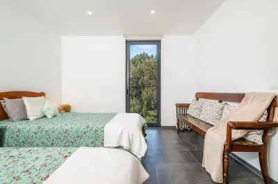 a bedroom with two beds and a window at SUPER Camacha - Casa da Eira in Camacha