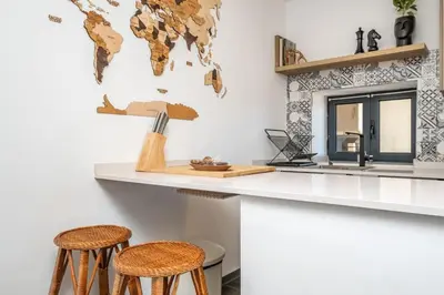 a kitchen with a counter and two stools at SUPER Camacha - Casa da Eira in Camacha