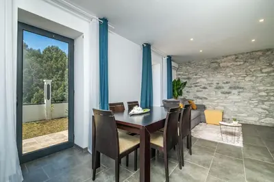 a dining room with a table and chairs and a large window at SUPER Camacha - Casa da Eira in Camacha