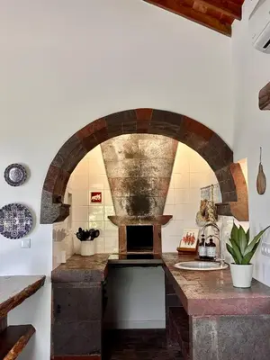 a kitchen with a stone oven in a room at Aldeia in Chã de João Tomé