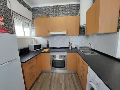 a small kitchen with wooden cabinets and a sink at Sea View 2-beds 'Estrela' Apartment - Praia da Luz in Luz