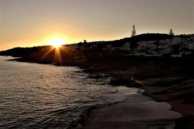 a sunset over a beach with the sun setting at Sea View 2-beds 'Estrela' Apartment - Praia da Luz in Luz