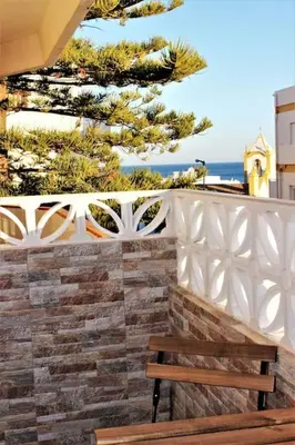 a wooden bench sitting next to a white fence at Sea View 2-beds 'Estrela' Apartment - Praia da Luz in Luz