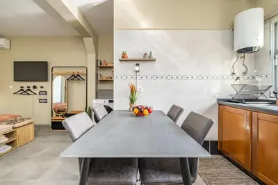 a kitchen and a dining room with a table and chairs at SUPER Seixal Beach - T0 in Seixal