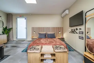 a bedroom with a large bed and a flat screen tv at SUPER Seixal Beach - T0 in Seixal