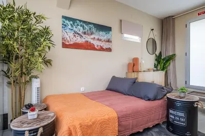 a bedroom with a bed and two potted plants at SUPER Seixal Beach - T0 in Seixal