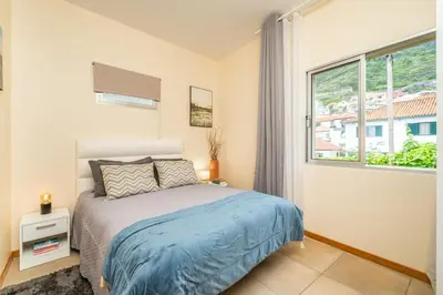 a bedroom with a bed and a large window at SUPER Seixal Beach - T2 in Seixal
