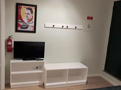 a white entertainment center with a flat screen tv on a wall at Classic Car House in Santa Cruz