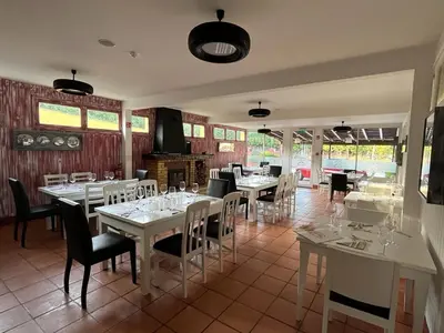 a restaurant with white tables and chairs and windows at Classic Car House in Santa Cruz