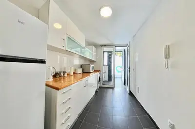a kitchen with white cabinets and a tile floor at Madeira Breeze in Funchal