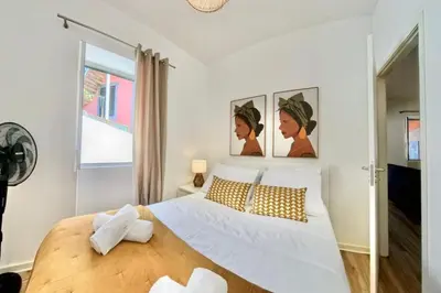 a bedroom with a large white bed and a window at Madeira Breeze in Funchal