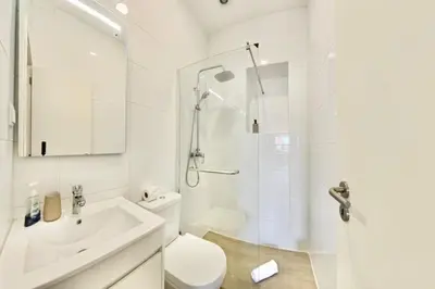 a white bathroom with a shower and a toilet at Madeira Breeze in Funchal