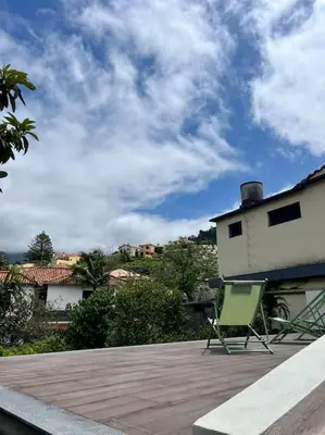 a green chair sitting on top of a patio at Villa with Mountain view, São Vicente, Madeira in São Vicente