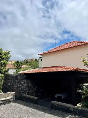 a building with a stone wall and a roof at Villa with Mountain view, São Vicente, Madeira in São Vicente