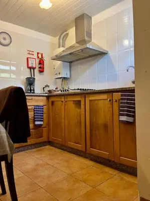 a kitchen with wooden cabinets and a stove at Villa with Mountain view, São Vicente, Madeira in São Vicente