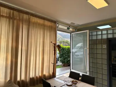 a dining room with a table and a sliding glass door at Xanda Escape in Machico