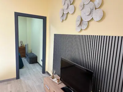 a living room with a flat screen tv and a mirror at Xanda Escape in Machico