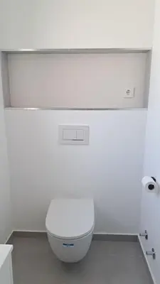 a bathroom with a white toilet in a white room at 5 bedroom Beach house in Luz, Lagos in Luz