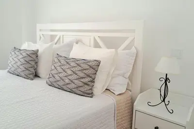 a white bed with four pillows on top of it at 5 bedroom Beach house in Luz, Lagos in Luz