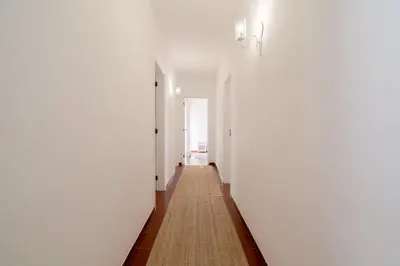 an empty hallway with white walls and a carpet at 5 bedroom Beach house in Luz, Lagos in Luz
