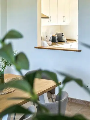 a kitchen with a wooden table and a mirror at Vila Agora Luz in Luz