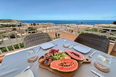 a table with a plate of food on top of a balcony at Vila Agora Luz in Luz